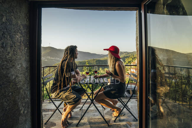 Пара расслабляющий, пить вино на солнечном балконе — стоковое фото