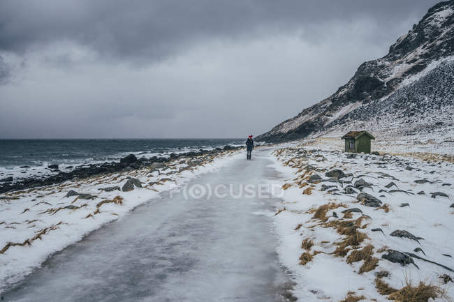 Frau läuft an eisigem Strand, erhabenen Inseln, Norwegen — Stockfoto