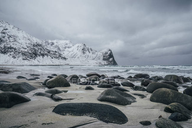 Rocas sobre nieve, playa remota, Islas Lofoten, Noruega - foto de stock