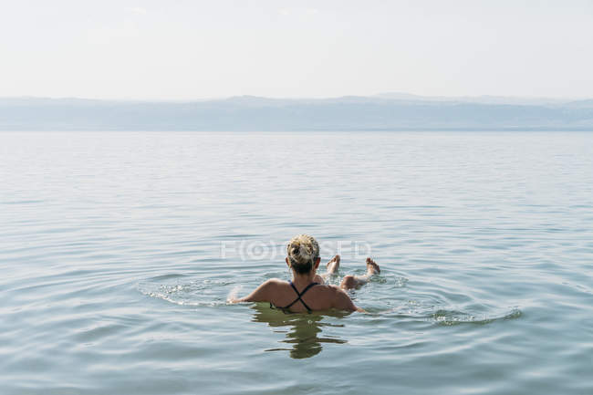 Жінка плаваючі, купання в Мертве море, Йорданія — стокове фото