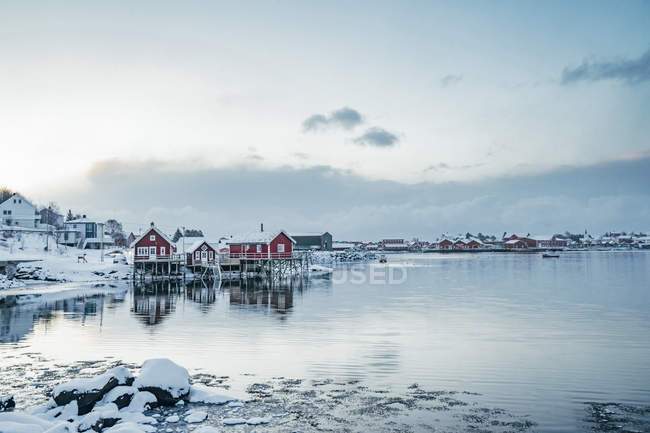 Ruhige Aussicht schneebedecktes Fischerdorf am Wasser, reine, erhabene Inseln, Norwegen — Stockfoto