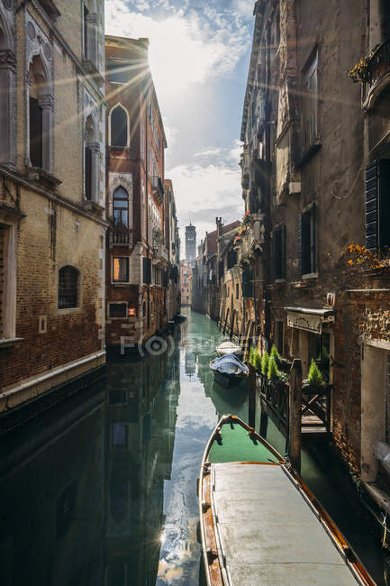 Sol brilhando sobre edifícios tranquilos e canal com gôndolas, Veneza, Itália — Fotografia de Stock