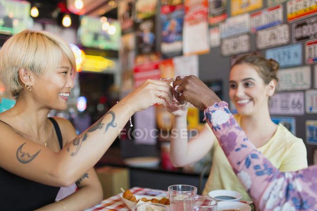 Young women friends taking alcohol shots in bar — Stock Photo