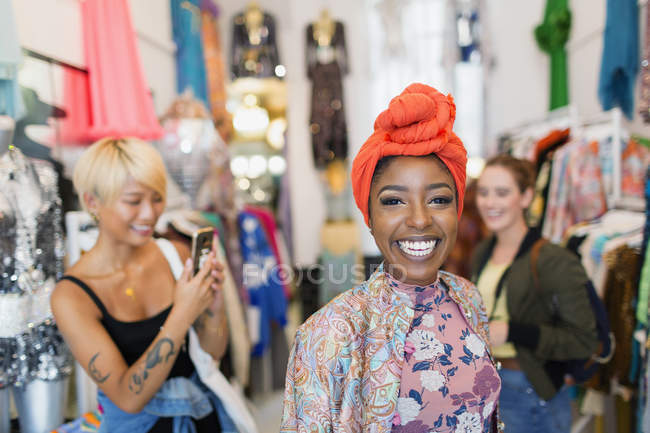 Portrait enthusiastic young woman shopping with friends in clothing store — Stock Photo