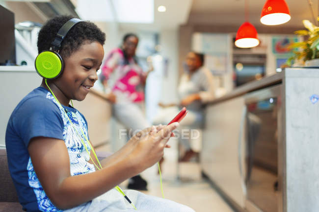 Мальчик с наушниками и цифровым планшетом играет в видеоигру — стоковое фото