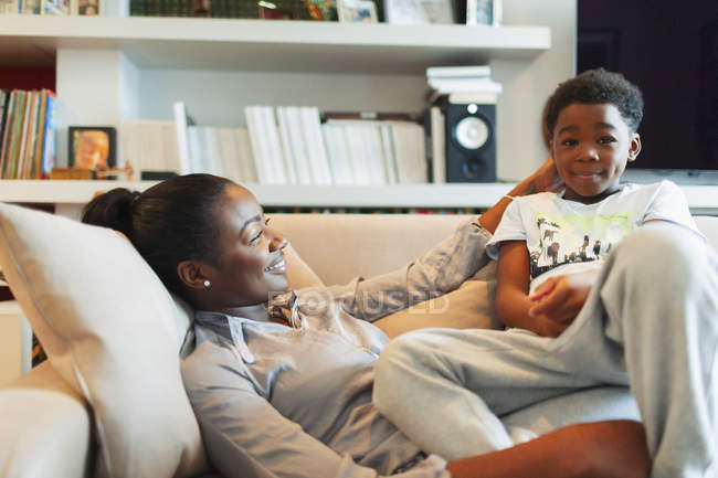 Affettuosa madre e figlio coccole sul divano del soggiorno — Foto stock
