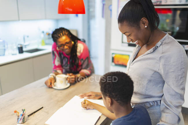 Multi-generation family coloring in kitchen — Stock Photo