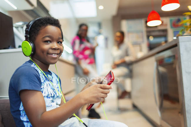 Portrait smiling, confident boy playing video game with headphones and digital tablet — Stock Photo
