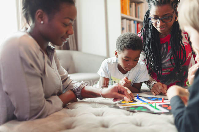 Multi-generation family playing board game — Stock Photo