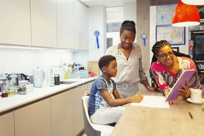 Famille avec tablette numérique dans la cuisine — Photo de stock