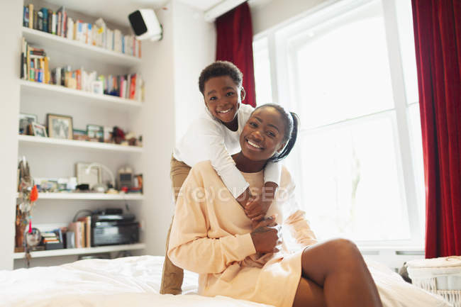 Ritratto affettuoso madre e figlio abbracciati sul letto — Foto stock