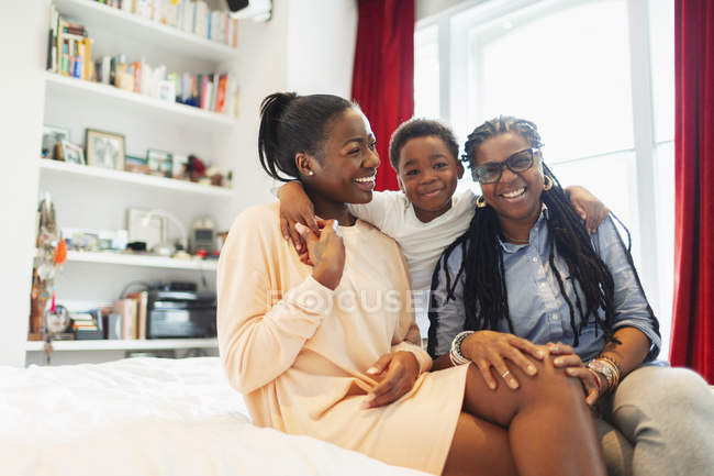 Portrait happy multi-generation family hugging on bed — Stock Photo