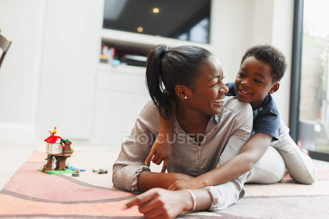 Ласковые мать и сын на полу гостиной — стоковое фото