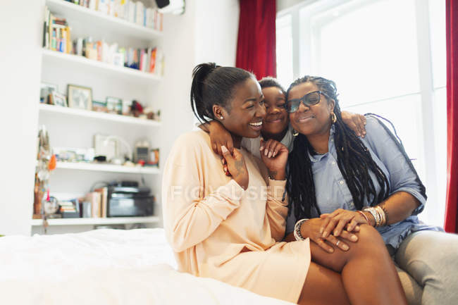 Affettuoso abbraccio familiare multi-generazione sul letto — Foto stock