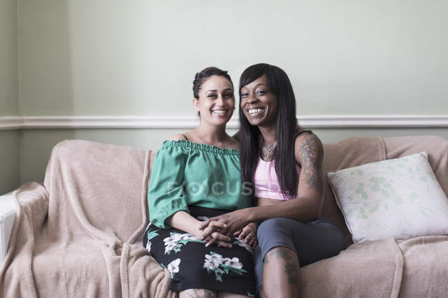 Ritratto felice, coppia lesbica affettuosa che si tiene per mano sul divano del salotto — Foto stock