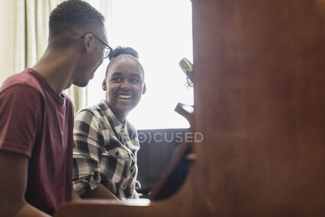 Happy brother and sister playing piano — Stock Photo