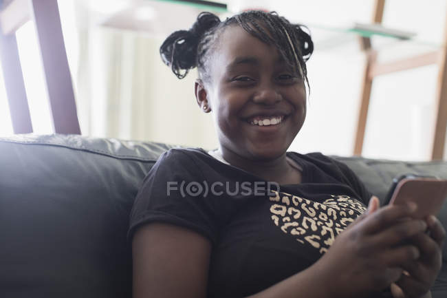 Porträt lächelnd, selbstbewusstes Mädchen, das mit dem Smartphone SMS schreibt — Stockfoto