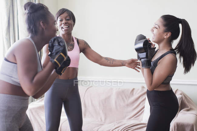 Madre enseñando a hijas boxeo - foto de stock