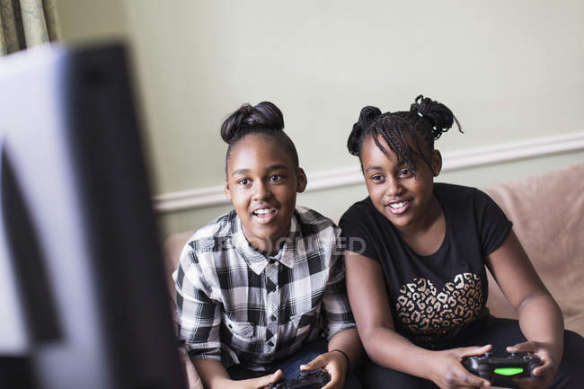 Друзья-подростки играют в видеоигры в гостиной — стоковое фото