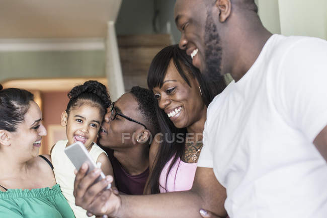 Happy lesbian couple and children with smart phone — Stock Photo