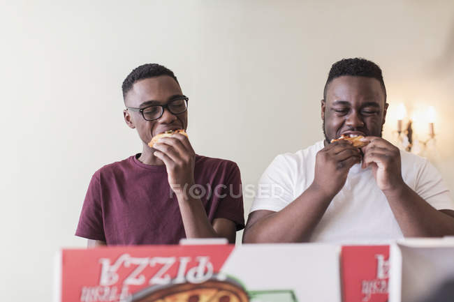 Fratelli adolescenti che mangiano pizza — Foto stock