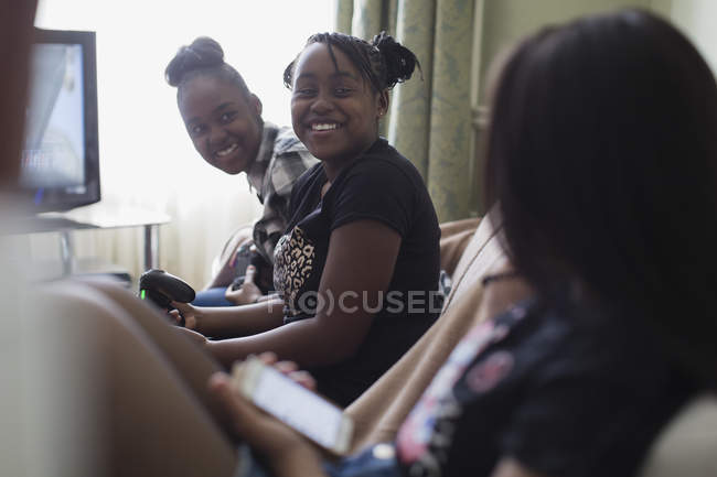 Happy tween girl friends playing video game in living room — Stock Photo