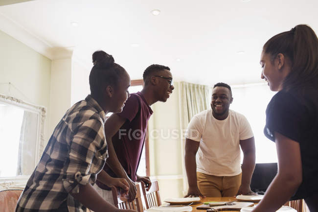 Felizes irmãos adolescentes colocando a mesa — Fotografia de Stock