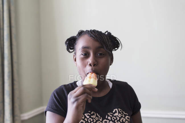 Portrait confident tween girl eating flavored ice — Stock Photo