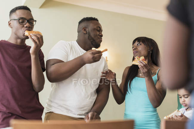 Семья ест пиццу и разговаривает — стоковое фото