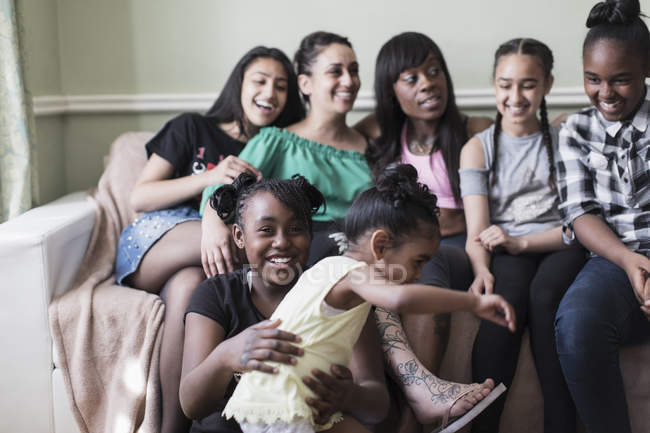 Coppia lesbica e bambini sul divano del soggiorno — Foto stock