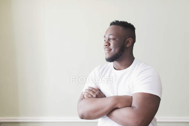 Portrait confident teenage boy with arms crossed looking away — Stock Photo