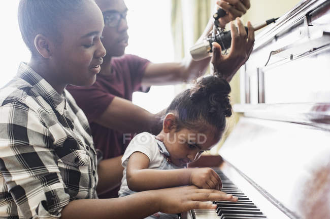 Frère et sœurs jouant du piano — Photo de stock