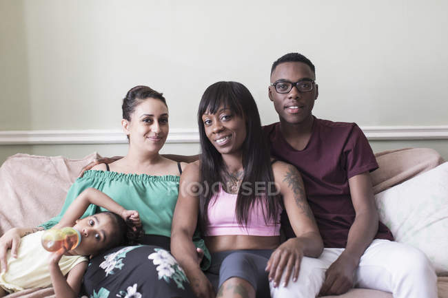 Портрет счастливая лесбийская пара и дети на диване гостиной — стоковое фото