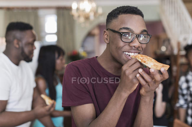 Retrato sorrindo adolescente comendo pizza com a família — Fotografia de Stock