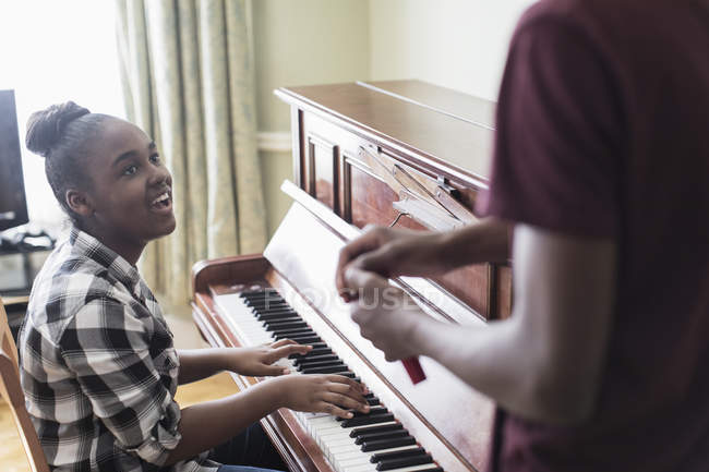 Улыбающаяся девочка, играющая на пианино — стоковое фото