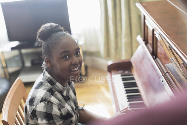 Усміхнена дівчина грає на піаніно — стокове фото