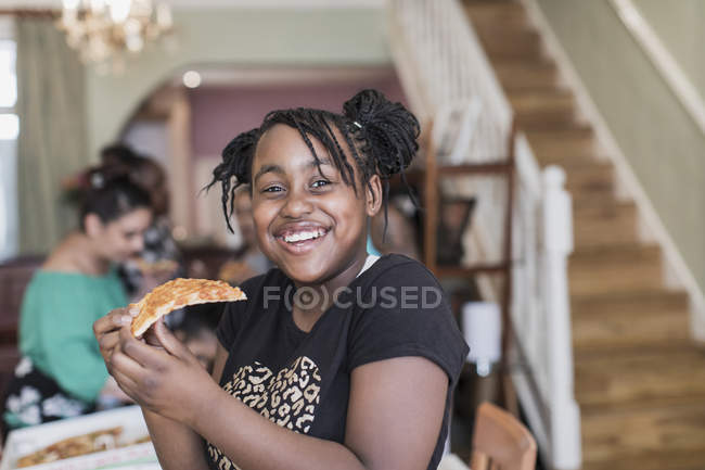 Retrato confiante tween menina comer pizza — Fotografia de Stock