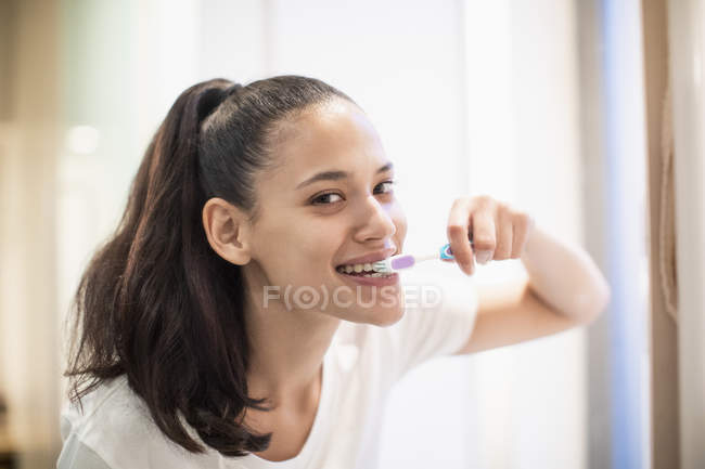 Портрет уверенной женщины чистящей зубы — стоковое фото