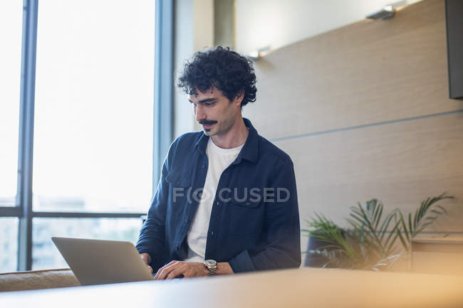 Hombre usando el ordenador portátil en casa - foto de stock