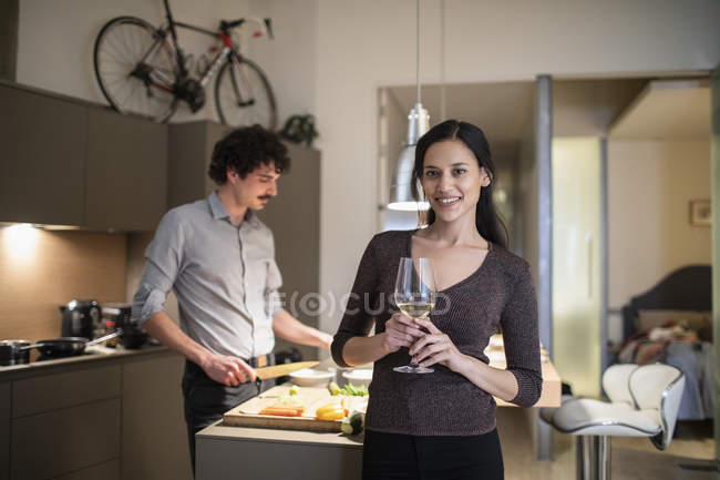 Portrait confident woman drinking white wine in apartment kitchen — Stock Photo
