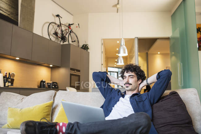 Hombre relajante en sofá apartamento - foto de stock