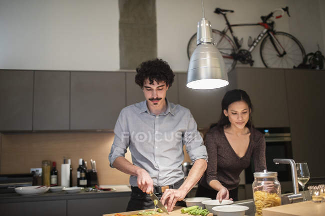 Пара резки овощей, приготовление ужина в квартире кухня — стоковое фото