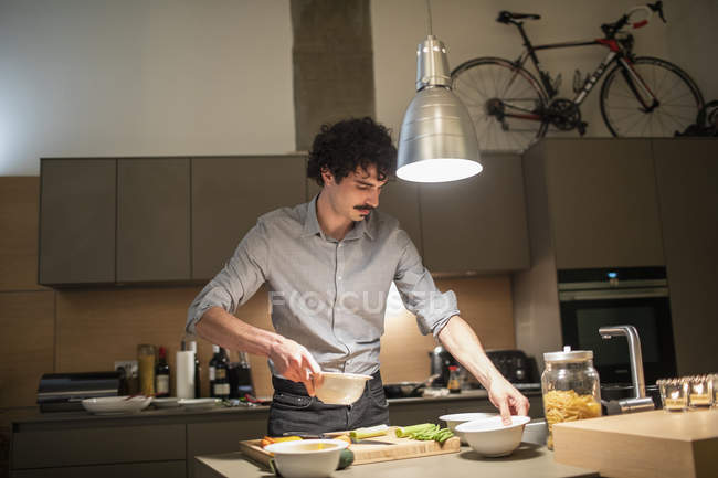 Homem cozinhar jantar na cozinha apartamento — Fotografia de Stock