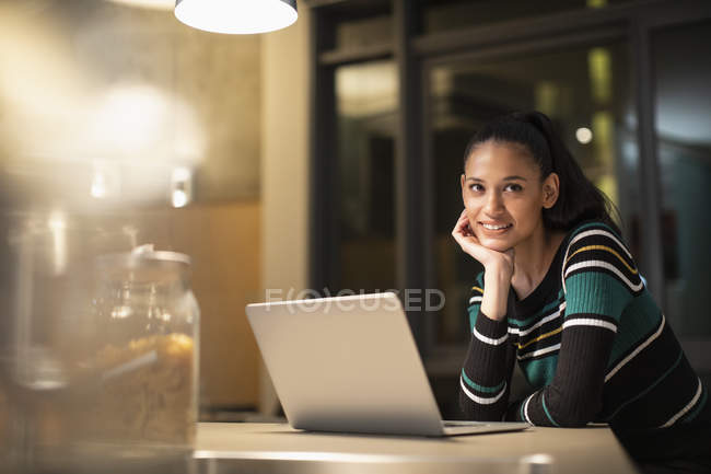 Portrait smiling, confident woman using laptop at home at night — Stock Photo