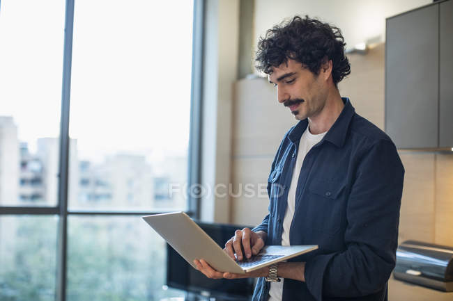 Людина використовує ноутбук у квартирі — стокове фото