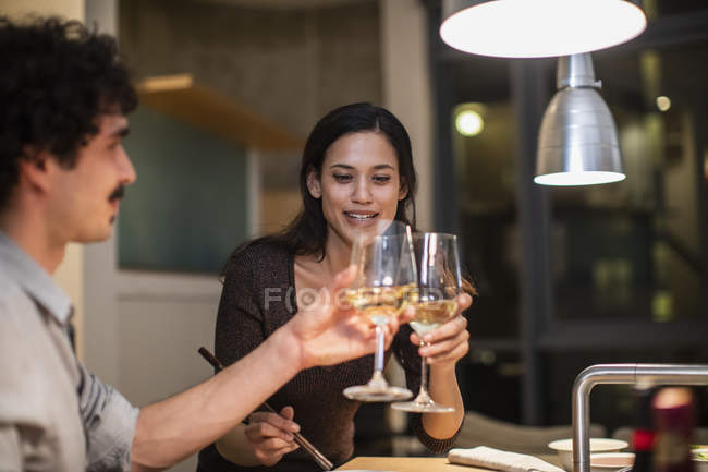 Casal brindar copos de vinho branco na cozinha apartamento — Fotografia de Stock