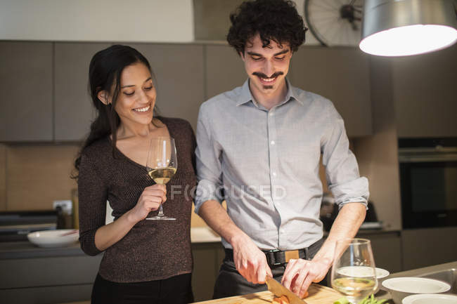 Happy couple préparer le dîner et boire du vin blanc dans la cuisine de l'appartement — Photo de stock