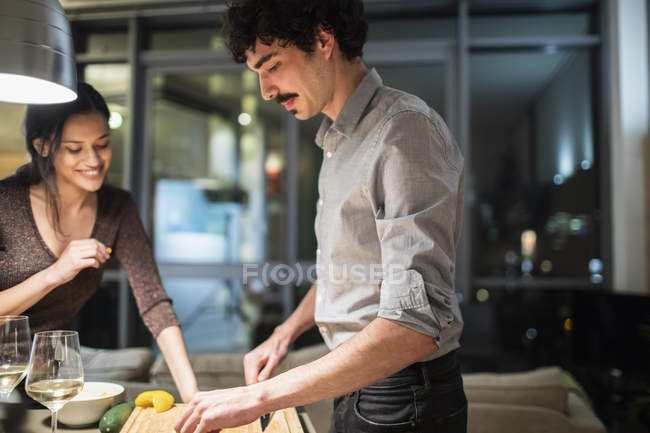 Couple cooking dinner in apartment kitchen at night — Stock Photo