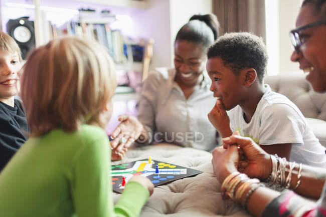 Happy family playing board game — Stock Photo