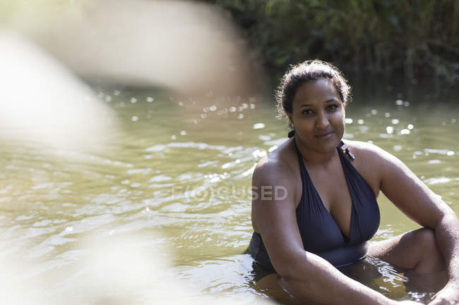 Портрет улыбающейся женщины, отдыхающей в солнечной реке — стоковое фото